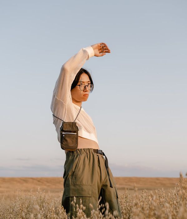 Woman in a calm yoga pose during sunset with soft light.